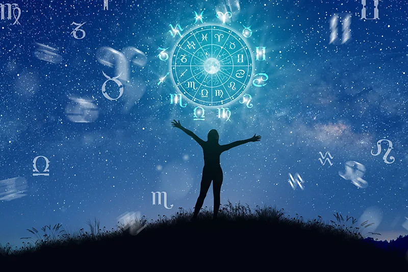 A wheel with astrological constellations in the background.