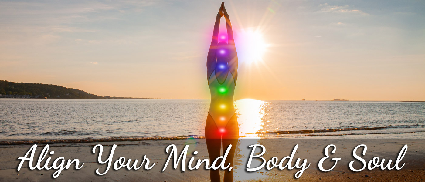 Align your mind, body and soul. A woman is doing yoga on a beach as the sun sits in the background. Glowing balls of color form a line through the center of the woman's soul.